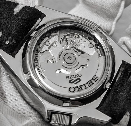 Partea din spate a unui ceas Seiko ce permite vizualizarea mecanismului automatic 4R36